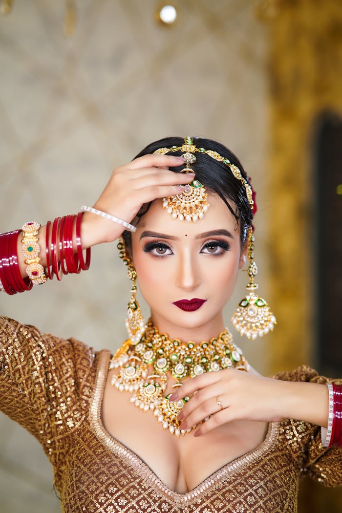 services-04 A portrait of a bride showcasing exquisite Indian jewelry and traditional attire indoors.
